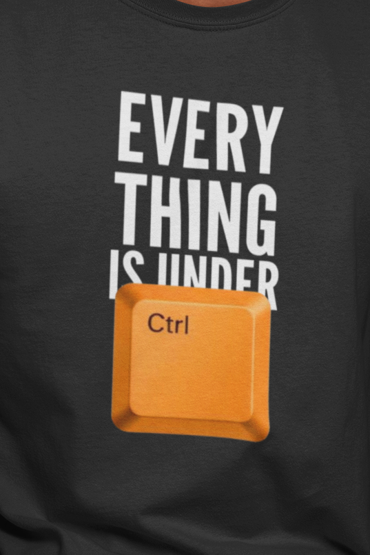 Man wearing a black t-shirt with a graphic and text, sitting on a wooden stool against a plain background.